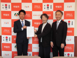 答申書を手渡す京樂会長と則安副会長