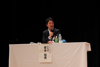 シンポジウムで登壇する市長